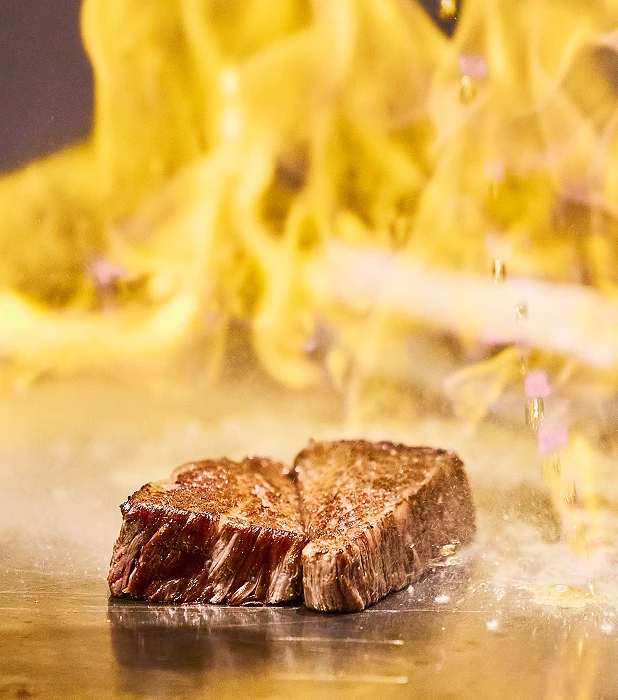 炎の中で焼き上げられる鉄板ステーキ